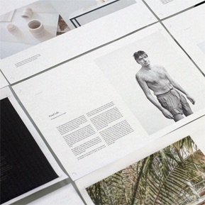 Magazine layout sheets spread neatly across a table.